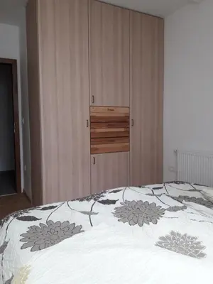 a bedroom with a bed with a wooden cabinet at Simnovi apartmaji - surrounded by nature in Kamnik