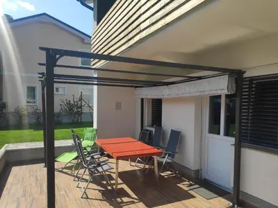 a patio with a table and chairs on a deck at Apartment GREEN&URBAN in Celje