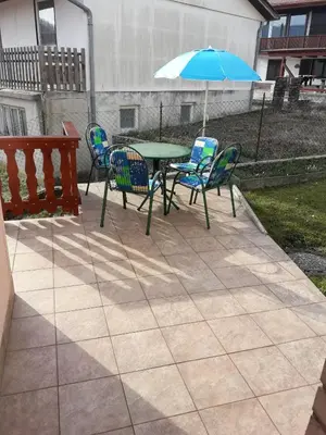 a patio with a table and chairs and an umbrella at APARTMA SABOTIČ in Sedula
