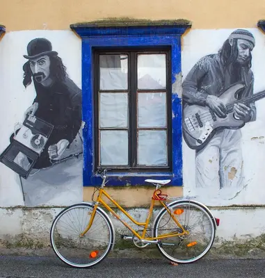 a bike parked in front of a wall with a mural at Goldenfields apartment in Kranj