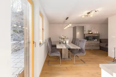 a dining room and kitchen with a table and chairs at Bohinj Cottage Pr' Maricki - house in nature with hot tub & sauna in Bohinj