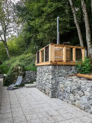 a bench sitting on top of a stone wall at Bohinj Cottage Pr' Maricki - house in nature with hot tub & sauna in Bohinj