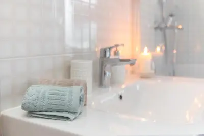 a bathroom with a sink and a bath tub with towels at Bohinj Cottage Pr' Maricki - house in nature with hot tub & sauna in Bohinj