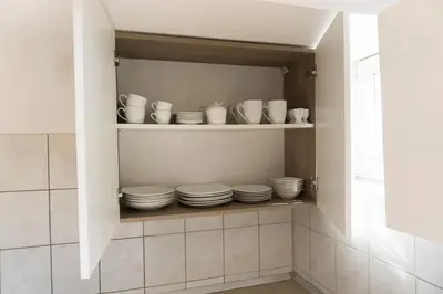 a cabinet filled with plates and cups and bowls at Trendy apartmant in city in Maribor