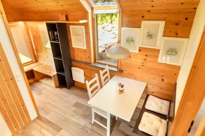 a tiny house with a white table and chairs at Glamping Mountain Fairy Tale in Bistrica pri Tržiču