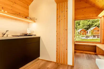 a kitchen with a large window in a log cabin at Glamping Mountain Fairy Tale in Bistrica pri Tržiču