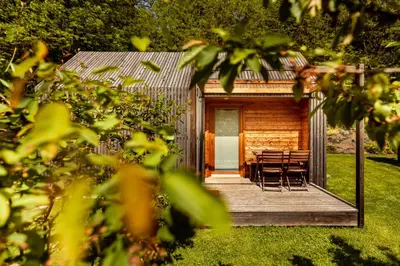 a log cabin with tables and chairs on a porch at Glamping Mountain Fairy Tale in Bistrica pri Tržiču