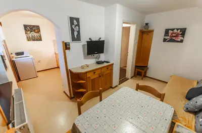 a small living room with a table and a television at Apartment Ticar in Bohinj
