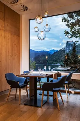 a dining room with a table and chairs and a large window at Hotel Park - Sava Hotels & Resorts in Bled