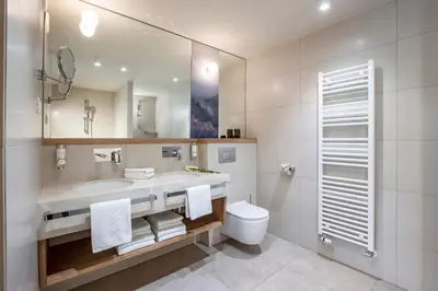 a bathroom with a sink and a toilet and a mirror at Hotel Park - Sava Hotels & Resorts in Bled