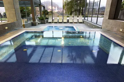a swimming pool with blue tiles in a building at Rikli Balance Hotel – Sava Hotels & Resorts in Bled