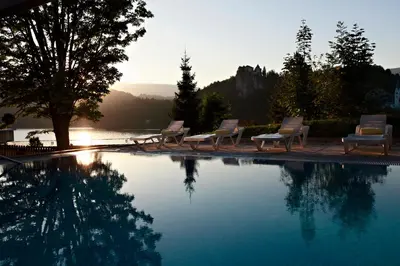 a group of chairs sitting around a swimming pool at Rikli Balance Hotel – Sava Hotels & Resorts in Bled