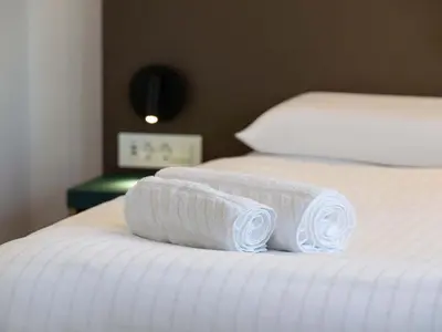 two rolled towels sitting on top of a bed at B&B HOTEL Maribor Orel in Maribor