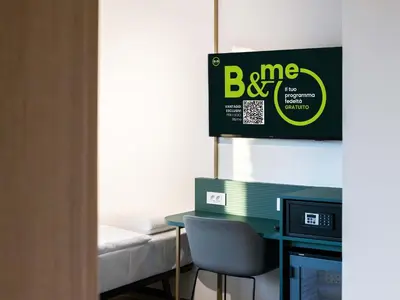 a room with a desk and a bed and a sign at B&B HOTEL Maribor Orel in Maribor