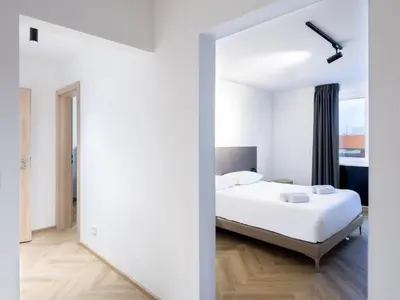 a bedroom with a white bed and a mirror at B&B HOTEL Maribor Orel in Maribor