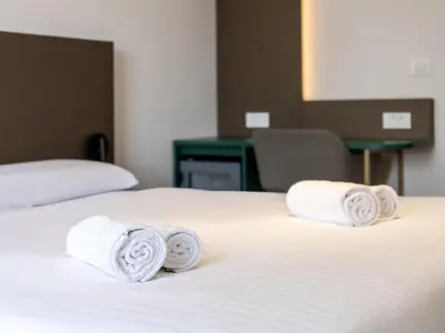 two rolled towels on a bed in a hotel room at B&B HOTEL Maribor Orel in Maribor