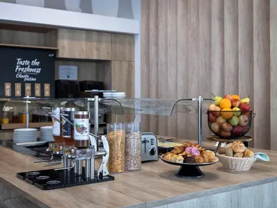 a counter with food on it with bowls of fruit at B&B HOTEL Maribor Orel in Maribor