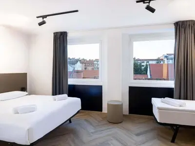 two beds in a room with two windows at B&B HOTEL Maribor Orel in Maribor