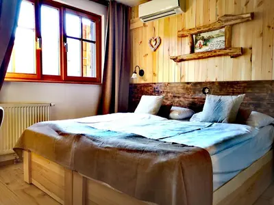 a bedroom with a large bed in a room with wooden walls at Ribno Alpine Hotel in Bled