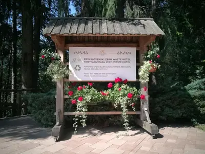 a sign in a garden with flowers on it at Ribno Alpine Hotel in Bled