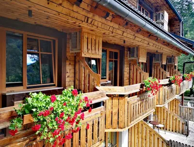 a wooden house with flowers on the balconies at Ribno Alpine Hotel in Bled