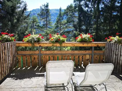 two chairs on a patio with flowers on a fence at Ribno Alpine Hotel in Bled