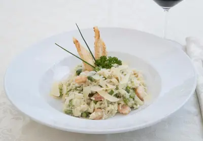 a white bowl of food with shrimp and rice at Hotel Grosuplje in Grosuplje