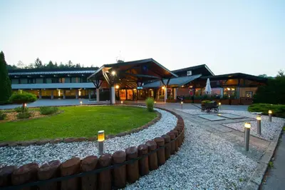 a large building with a yard with a stone path at Hotel Grosuplje in Grosuplje