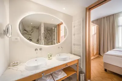 a bathroom with two sinks and a large mirror at Grand Hotel Union Eurostars in Ljubljana