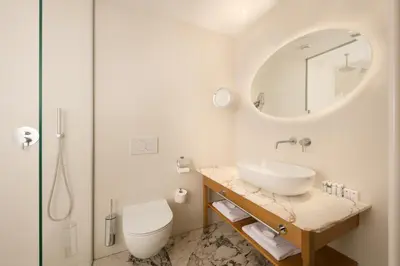 a bathroom with a sink and a toilet and a mirror at Grand Hotel Union Eurostars in Ljubljana