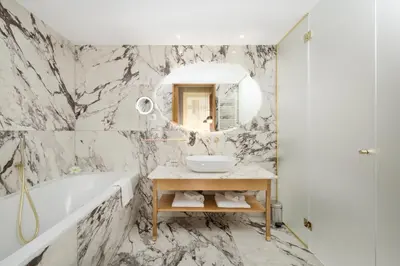 a bathroom with a tub and a sink and a mirror at Grand Hotel Union Eurostars in Ljubljana