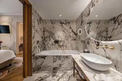 a bathroom with a white sink and a tub at Grand Hotel Union Eurostars in Ljubljana