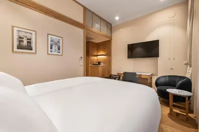 a hotel room with a bed and a chair and a television at Grand Hotel Union Eurostars in Ljubljana