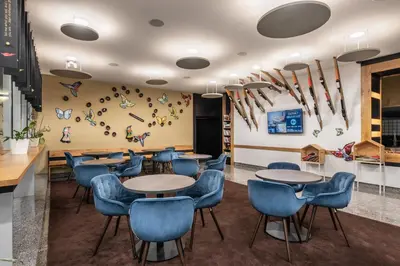 a dining room with tables and blue chairs at Eurostars uHOTEL in Ljubljana