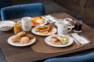 a table with plates of breakfast food on it at Eurostars uHOTEL in Ljubljana