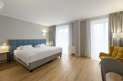 a hotel room with a bed and a chair at Eurostars uHOTEL in Ljubljana