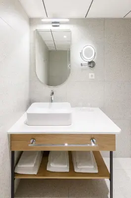 a bathroom with a sink and a mirror at Eurostars uHOTEL in Ljubljana