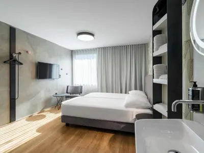 a hotel room with a bed and a sink at ibis Styles Ljubljana Centre in Ljubljana