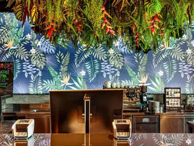 a restaurant with a blue wall with plants on it at ibis Styles Ljubljana Centre in Ljubljana