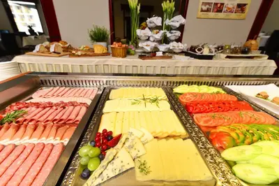 a buffet with many different types of meats and vegetables at Hotel Kompas in Bled