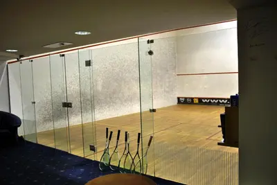 a room with a tennis court with a bunch of tennis rackets at Hotel Kompas in Bled