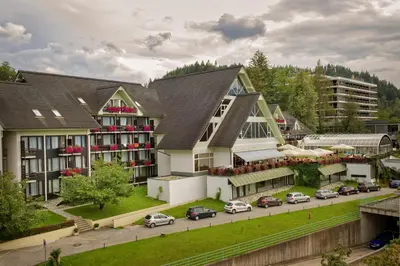 a large building with cars parked in front of it at Hotel Kompas in Bled