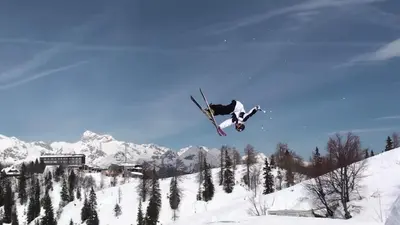 a person jumping in the air on skis in the snow at Hotel Jezero in Bohinj