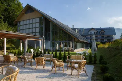 a group of chairs and tables in front of a building at Hotel Jezero in Bohinj