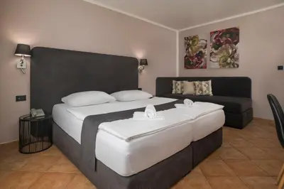 a bedroom with a large bed and a couch at Ljubljana Resort Hotel & Camping in Ljubljana