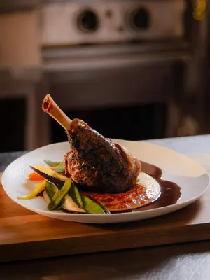 a plate of meat and vegetables on a table at Ljubljana Resort Hotel & Camping in Ljubljana