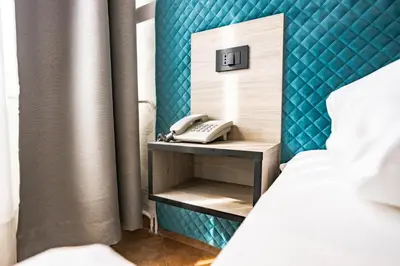 a bed and a phone on a nightstand next to a bed at Ljubljana Resort Hotel & Camping in Ljubljana