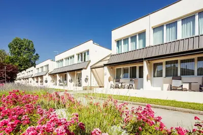 a row of buildings with flowers in the foreground at Ljubljana Resort Hotel & Camping in Ljubljana