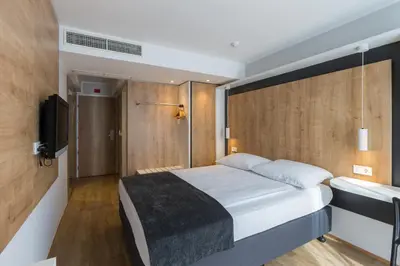 a bedroom with a large bed and a television at M Hotel in Ljubljana
