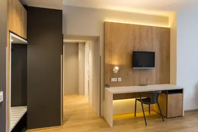 a room with a desk and a tv on a wall at M Hotel in Ljubljana